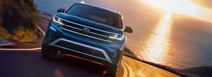 2023 Volkswagen Atlas driving around bend on cliffside road