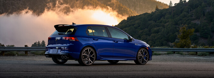 Blue 2023 Volkswagen Golf R parked near mountain look out with fog