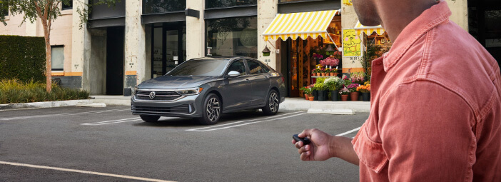Person unlocking 2023 Volkswagen Jetta from across parking lot using keyless fob