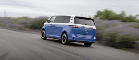 Rear view blue vw buzz driving near grass land