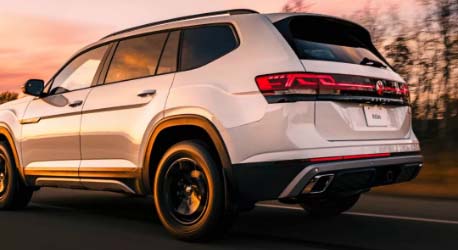 Side_rear_view_white_vw_driving_on_road