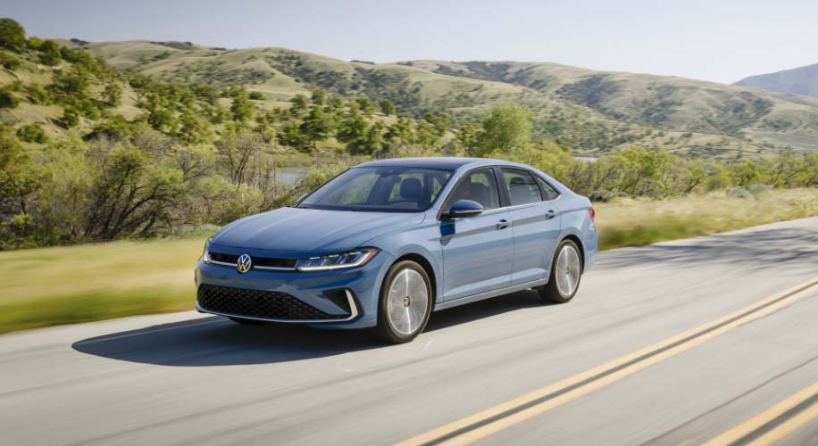 Side view of the 2026 Volkswagen Jetta in blue parked on a scenic road.