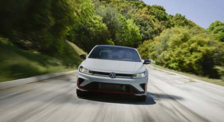 Front_view_vw_white_gli_driving_on_road