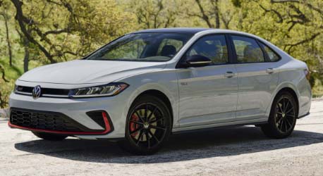 White_jetta_gli_parked_on_road_nera_grassy_hill