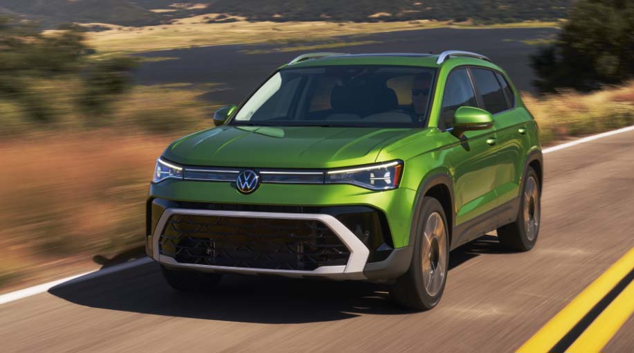 2026 Volkswagen Taos in motion with rolling hills and mountains in the backdrop