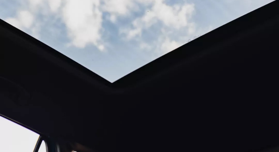 Open VW sunroof showing cloudy sky