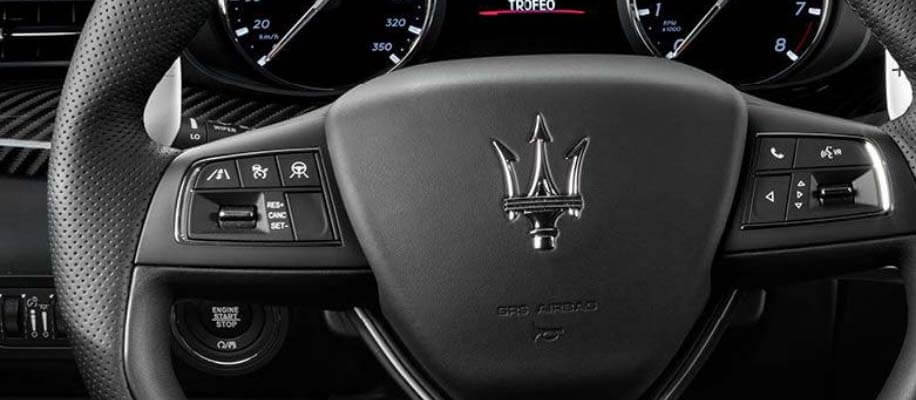 Close up of Maserati steering wheel and logo
